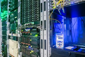 Measurement of the optical signal level by the reflectometer in the server room of the data center. Racks with servers and routers. Powerful Internet equipment